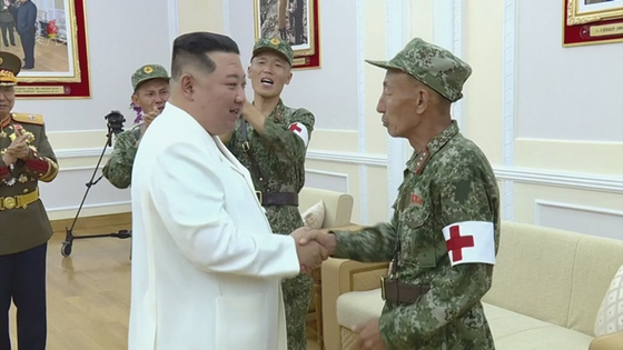 김정은 북한 국무위원장이 지난 18일 비상방역전에서 임무를 완수하고 위훈을 세운 군의부문(의무부대) 전투원들을 만나 격려하는 모습. 〈사진-조선중앙 TV·연합뉴스〉