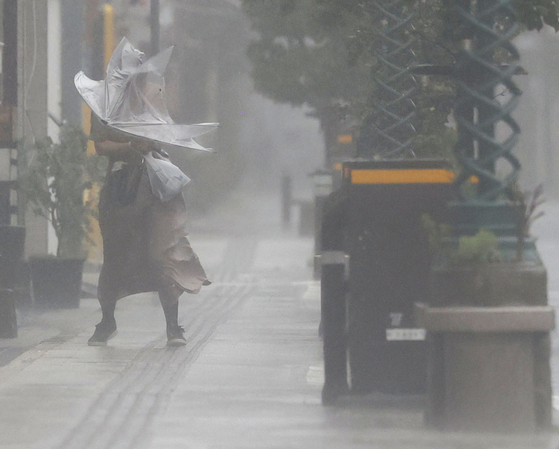 제14호 태풍 '난마돌'이 북상하는 지난 18일 오후 일본 미야자키현 미야자키시에서 우산을 든 시민이 강한 비바람을 맞으며 이동하고 있다. 〈사진=연합뉴스〉