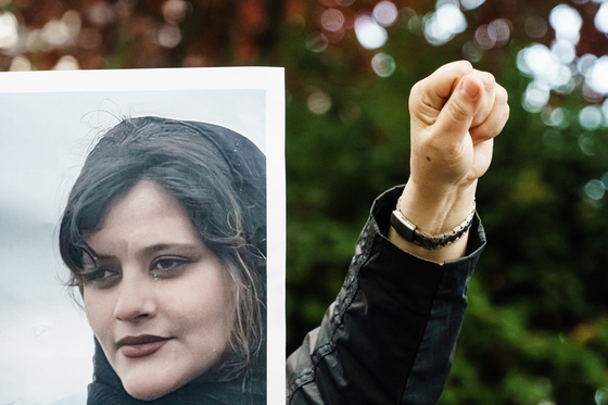 현지시간 20일 독일 베를린에 있는 이란 대사관 앞에서 히잡을 안 썼다는 이유로 경찰에 체포된 뒤 숨진 마흐사 아미니(22)의 모습이 담긴 플래카드를 들고 시위하고 있다. 〈사진=EPA 연합뉴스〉