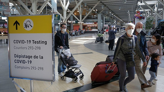 마스크를 쓴 채 캐나다 밴쿠버 공항을 빠져나오는 사람들. 〈사진-연합뉴스〉