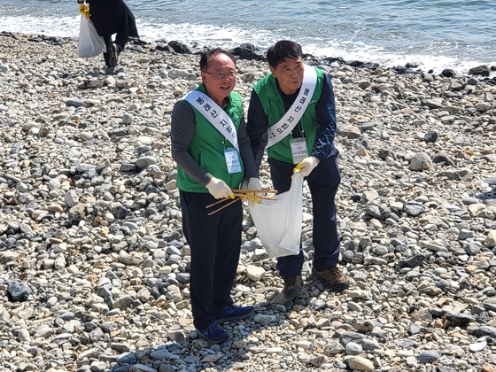 홍문기 HJ중공업 대표(왼쪽)가 부산 영도구 중리 해변에서 쓰레기를 수거하고 있다. [사진=조선옥 기자] 