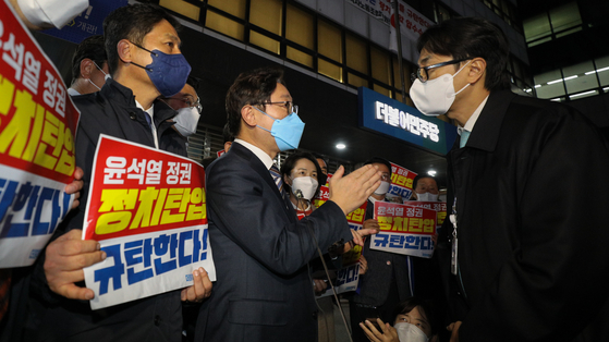 박범계 더불어민주당 의원이 지난 19일 서울 여의도 중앙당사 앞에서 민주연구원 압수수색에 나선 검찰 관계자들과 대치하던 중 대화를 시도하고 있다. 〈사진=공동취재·연합뉴스〉