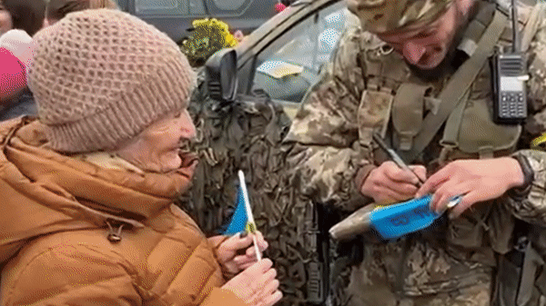 현지시간 12일 우크라이나 남부 헤르손에서 주민들이 군인들에게 사인과 사진을 요청하는 모습. 〈영상=CNN〉