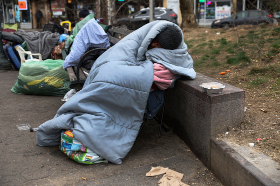 지난 3월 미국 뉴욕시 퀸스 자치구 지하철역 밖에서 한 노숙자가 공원 벤치에서 잠을 자고 있다. 〈사진=로이터 연합뉴스〉
