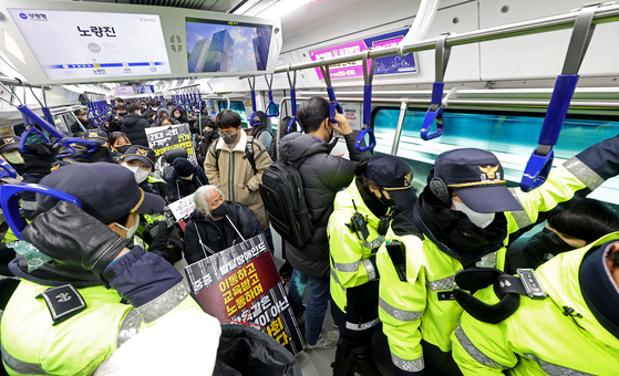 전국장애인차별철폐연대 회원들이 지난달 19일 오전 서울 지하철 1호선 용산역에서 지난 14일 지하철 탑승 시위 중 무정차 통과 조치에 규탄하며 기습시위를 하고 있다. 〈사진=연합뉴스〉