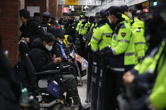 전국장애인차별철폐연대(전장연) 회원들이 2일 오전 서울 지하철 4호선 삼각지역 승강장에서 지하철 탑승을 시도하는 가운데 경찰이 배치돼 있다. 〈사진=연합뉴스〉