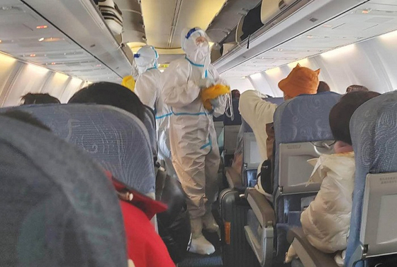 5일 중국으로 향하는 인천공항발 중국 항공사 여객기 안에서 승무원들이 방역복을 착용한 채 근무하고 있다. 〈사진=연합뉴스〉