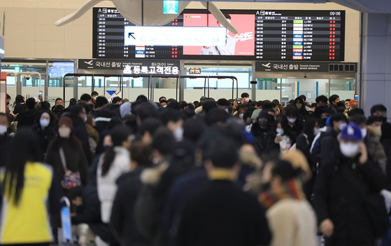 설 연휴 마지막 날인 24일 오전 폭설과 강풍이 몰아쳐 항공편이 전편 결항한 가운데 승객들이 대기표를 구하기 위해 각 항공사 대기전용 카운터에 길게 줄을 서 있다. 〈사진=연합뉴스〉