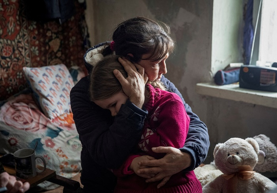 전쟁이 벌어지고 있는 우크라이나 도네츠크 지역에서 할머니가 손녀를 껴안고 있는 모습. (기사와 직접적인 관계 없음) 〈사진=로이터·연합뉴스〉  