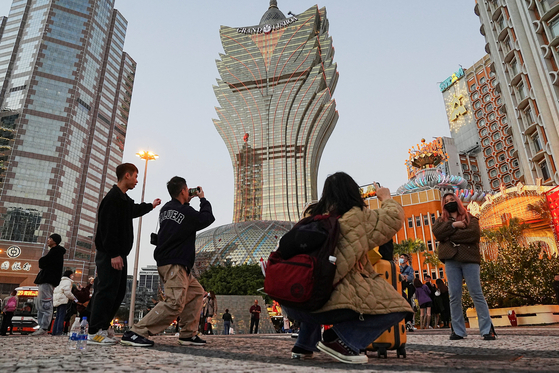 지난달 24일 중국 마카오에 있는 그랜드 리스보아 호텔&카지노 앞에서 사람들이 사진을 찍기 위해 포즈를 취하고 있다. 〈사진=로이터〉