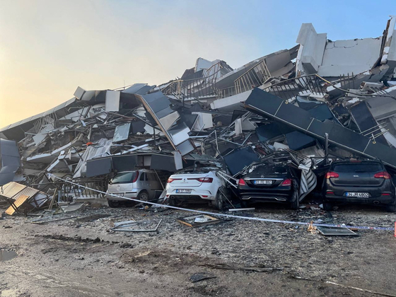 지난 6일 튀르키예 하타이주에서 발생한 지진으로 건물이 무너져 차량이 깔린 모습. 〈사진=로이터〉