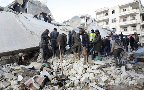 현지시간 7일 지진 피해를 본 시리아 잔다리스에서 생존자를 찾기 위해 건물 잔해 위에 서 있는 사람들. 〈사진=로이터 연합뉴스〉