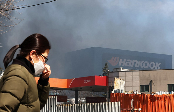  13일 오전 대전시 대덕구 목상동 한국타이어 공장에서 난 불로 인한 매캐한 연기가 인근 마을을 뒤덮자 시민들이 고통스러운 표정으로 발길을 옮기고 있다. 〈사진=연합뉴스〉