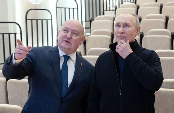 블라디미르 푸틴 러시아 대통령(오른쪽)이 러시아의 크림반도 병합 9주년을 맞은 18일(현지시간) 크림반도 남서부 항구도시 세바스토폴의 어린이 예술 공예센터를 방문해 미하일 라즈보자예프 시장(왼쪽)의 안내를 받고 있다. 〈사진=AFP 연합뉴스〉