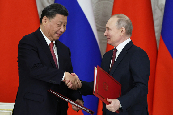 현지시간 21일 시진핑 중국 국가주석과 블라디미르 푸틴 러시아 대통령이 러시아 모스크바 크렘린궁에서 정상회담을 한 뒤 서명식에서 악수를 하고 있다. 〈사진=로이터〉