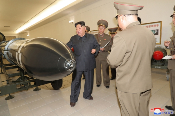 김정은 북한 국무위원장이 핵무기병기화사업을 지도하고 핵반격작전계획과 명령서를 검토했다고 조선중앙통신이 보도했다. 김정은이 미사일 탄두 부분을 가리키고 있다. 〈사진=연합뉴스〉