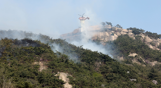 2일 오후 산불이 발생한 서울 종로구 인왕산에서 헬기가 진화 작업을 하고 있다. 〈사진=연합뉴스〉