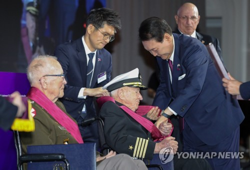 윤석열 대통령이 현지 시간 25일 한국전 참전용사 앨머 로이스 윌리엄스 예비역 해군 대령에게 무공훈장을 친수하고 있다. 〈사진=연합뉴스〉