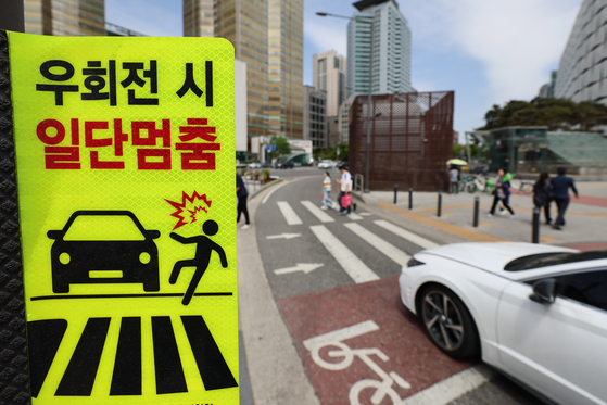 경찰이 교차로 우회전 시 일시정지 단속을 개시한 가운데 지난 23일 오후 서울 시내 한 교차로에 우회전 시 일단멈춤 표시판이 붙어있다.  〈사진=연합뉴스〉