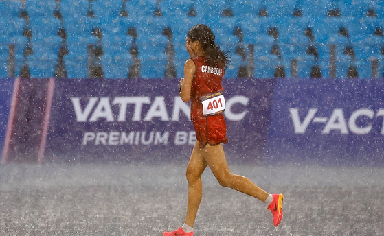 쏟아지는 빗방울 속에서 달리고 있는 보우 삼낭 선수.〈사진=IOC 제공〉