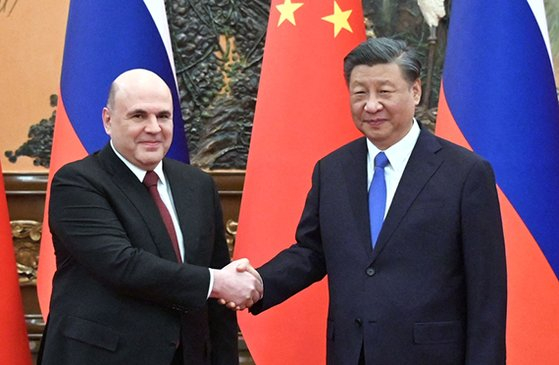 24일 시진핑(오른쪽) 중국 국가주석이 미하일 미슈스틴(왼쪽) 러시아 총리와 베이징 인민대회당에서 회담에 앞서 악수하고 있다. 〈사진= AFP,연합뉴스〉