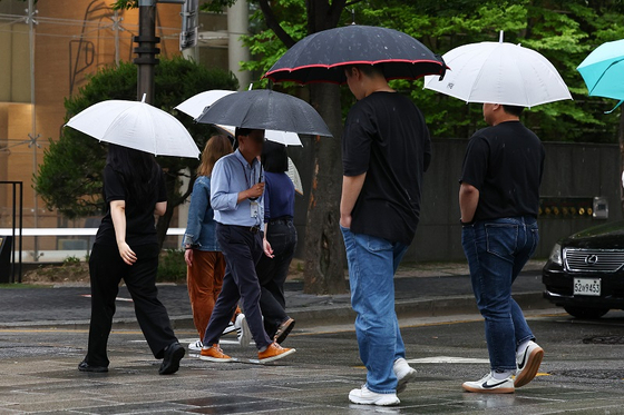 비가 내린 지난 18일 서울 시내에서 시민들이 우산을 쓰고 걷고 있다. 〈사진=연합뉴스〉
