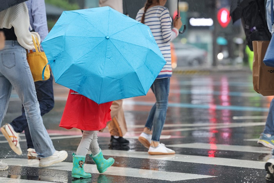 지난 27일 오후 서울 광화문네거리에서 어린이가 우산을 쓰고 횡단보도를 건너는 모습. 〈사진=연합뉴스〉 