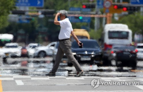 15일 오후 광주 서구 내방로에서 시민들이 뜨거운 햇볕에 달아올라 아지랑이가 피어오르는 도로를 건너고 있다. 〈사진=연합뉴스〉