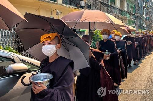 폭염으로 인해 머리에 수건과 우산을 쓴 미얀마인들. 〈사진=연합뉴스〉