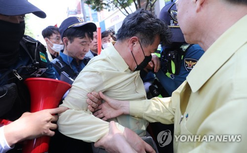 대구퀴어문화축제 행정대집행 현장에서 한 공무원이 부상을 주장하며 현장 밖으로 이동하고 있다. 〈사진=연합뉴스〉