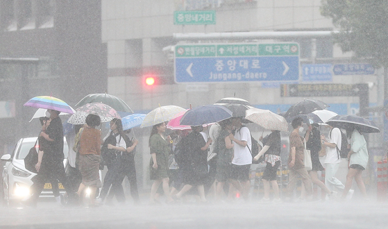 7일 오후 대구 중구 동성로에서 시민들이 장맛비 속에서 우산을 쓰고 이동하고 있다. 〈사진=연합뉴스〉