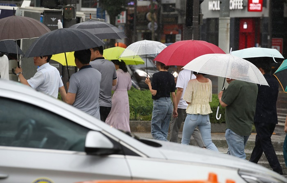 비가 내린 어제(7일) 오후 광주광역시 북구청 앞에서 시민들이 우산을 쓰고 걷는 모습. 〈사진=연합뉴스〉 