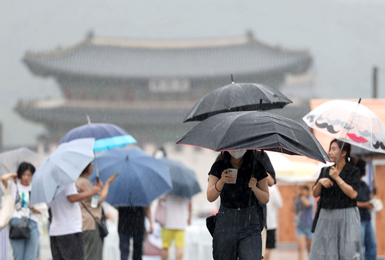 23일 오전 서울 광화문광장에서 우산을 쓴 시민들이 걸어가고 있다. 〈사진=연합뉴스〉