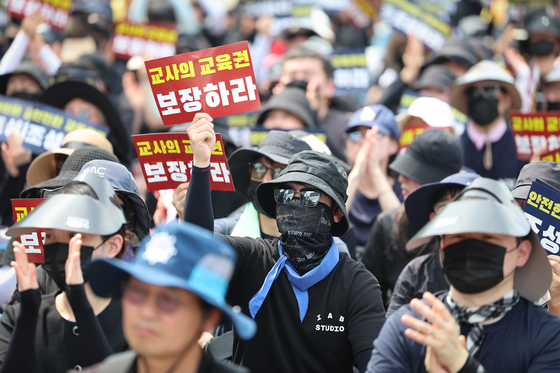 전국 각지에서 모인 교사들이 29일 서울 종로구 경복궁역 사거리 인근에서 열린 공교육 정상화를 위한 집회에 참석해 팻말을 들고 있다. 〈사진=연합뉴스〉