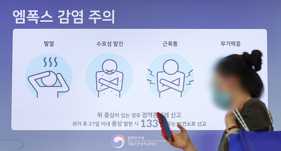 지난 5월 인천국제공항 제1여객터미널 출국장에 설치된 스크린에 엠폭스 관련 안내문이 띄워져 있다. 〈사진=연합뉴스〉