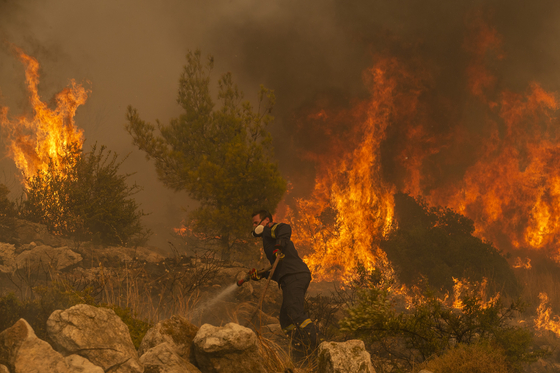 22일(현지시간) 그리스 아테네 인근 하시아 마을에서 소방관이 산불을 진압하고 있다 〈사진=연합뉴스〉