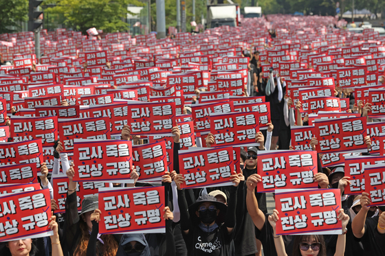 지난 26일 오후 서울 영등포구 국회 앞에서 전국교사일동이 연 '국회 입법 촉구 추모집회'에서 참가자들이 손팻말을 들고 있다. 〈사진=연합뉴스〉