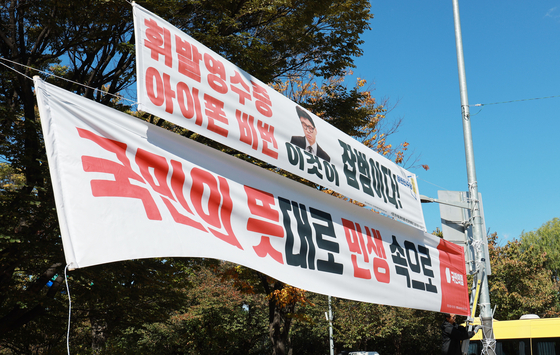 20일 서울 서강대교 남단사거리에서 관계자들이 정쟁성 현수막을 철거하고 새로운 현수막을 설치하고 있다. 〈사진=연합뉴스〉