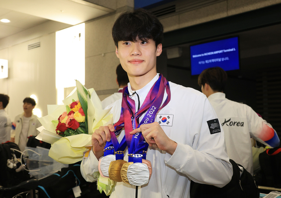 황선우 수영선수가 9월 30일 오후 인천국제공항 제1여객터미널을 통해 귀국한 뒤 메달을 들어보이고 있다. 〈사진=연합뉴스〉