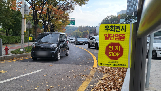 교통섬 안전 펜스에 '우회전시 일단멈춤' 안내문이 붙어있다. 〈사진=이지현 기자〉