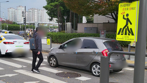 교통섬 횡단보도. 사람이 보행 중임에도 멈추지 않는 차들. 〈사진=이지현 기자〉