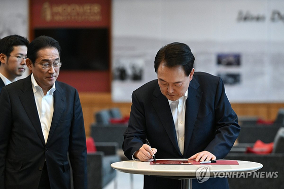 아시아태평양경제협력체(APEC) 정상회의 참석차 미국을 방문 중인 윤석열 대통령이 현지 시간 17일 미국 캘리포니아주 스탠퍼드대 후버연구소에서 열린 한일 정상 좌담회를 마친 뒤 좌담회 안내 인쇄물에 기념서명을 하고 있다. 〈사진=연합뉴스〉