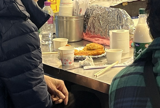 광장시장에서 전을 먹고 있는 시민의 모습. 〈사진=유혜은 기자〉