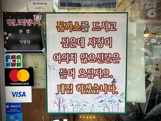 서울 동교동 한 돈가스 가게 앞에 붙은 안내문. 〈사진=김휘란 기자〉