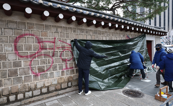 16일 오전 서울 종로구 경복궁 영추문 담벼락에 누군가 스프레이로 낙서한 부분이 천막으로 가려져 있다. 〈사진=연합뉴스〉