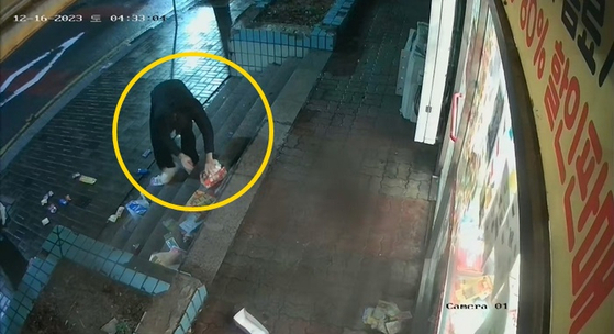 한 행인이 점포 앞에 널브러진 상품들을 주워 매장으로 옮기는 모습. 〈사진=피해 업주가 공개한 CCTV 영상 캡처·연합뉴스〉