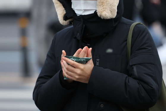 한 시민이 핫팩을 들고 이동하고 있다. 〈자료사진=연합뉴스〉