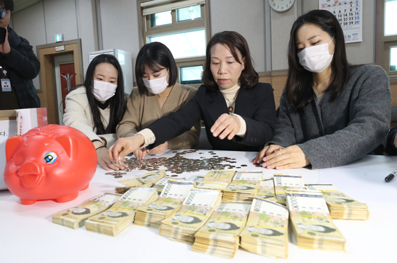 27일 오전 전주시 노송동주민센터에서 직원들이 '얼굴 없는 천사'가 두고 간 성금을 세고 있다. 〈사진=전주시 제공〉