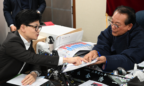 한동훈 비대위원장에게 사진을 보여주고 있는 김호일 대한노인회 회장 〈사진=연합뉴스〉