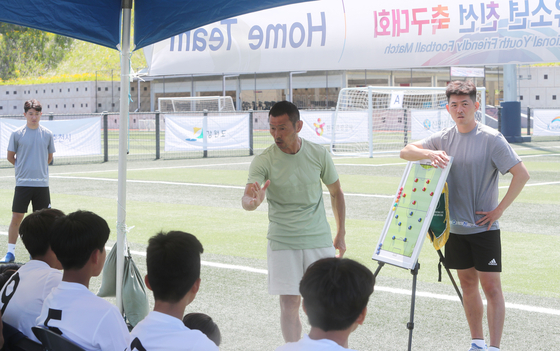 아이들에게 축구 지도중인 손웅정 감독과 손흥윤 수석코치(오른쪽) (사진=연합뉴스)